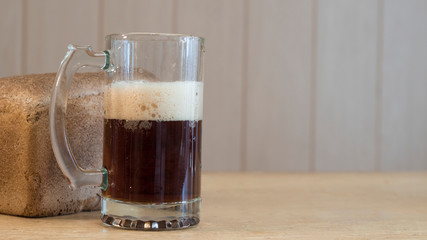 Glass mug of dark beer on the table with copy space