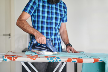 headless view of man ironing at home in a steamy atmosphere