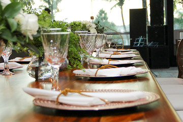 buffet table set up and decorated for the event with dishes, cutlery, napkins, glasses and bowls