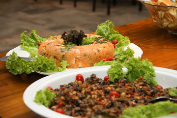 natural couscous salad of corn flour, eggs, olives, decorated with cherry tomatoes, parsley, green lettuce, purple lettuce and accompanied by oven eggplant salad,  selective focus