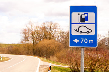 Electric car charging point sign in nature. EV parking and recharging road sign. 