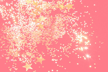 gold glitter confetti on a coral background