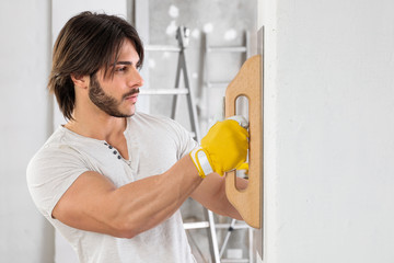 Plasterer finishing the surface of a white wall