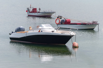 white motor boat at anchor near the coast
