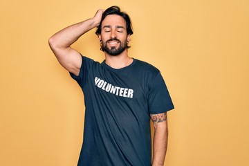Young handsome hispanic volunteer man wearing volunteering t-shirt as social care smiling confident...