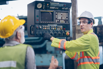 worker standing  with mentor and control machine  on manual hand in factory