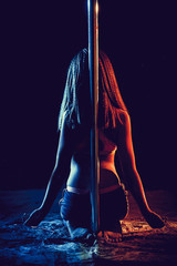 girl sitting next to the pole on a black background