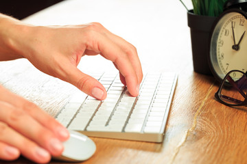 Female hands typing on white wireless modern keyboard  on wooden table   - Image