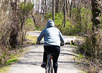 Close up of person riding a bicycle in woods wearing a hoody