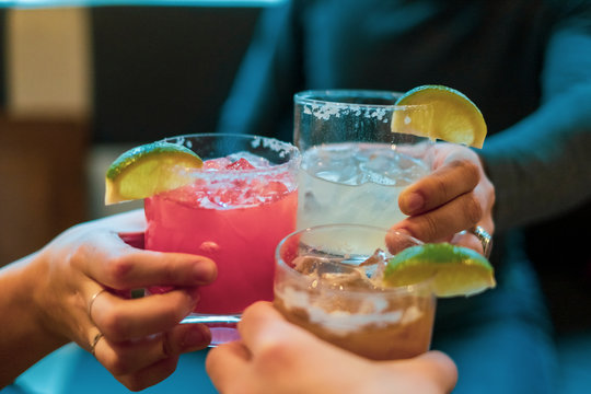 Friends toasting (cheers) with margaritas of different flavors