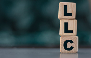 LLC word on cubes on a beautiful grey greener background