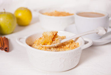 Tasty homemade apple crumble dessert on the white background.
