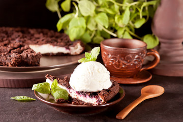 Creamy cheesecake with chocolate, black currant, ice cream and mint leaf for decoration.