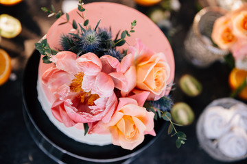 Fototapeta premium wedding cake in coral decorated with fresh flowers