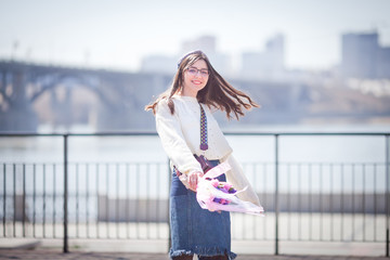 beautiful girl walks with a bouquet of spring flowers along the promenade