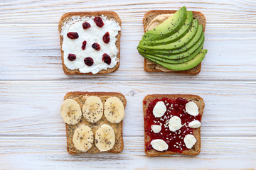 Top view of wholegrain bread toast, avocado toast, peanut paste toast, raspberry jam toast