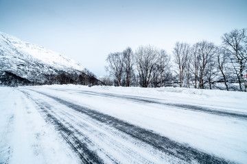 Obraz na płótnie Canvas Icy road against snowcapped mountain
