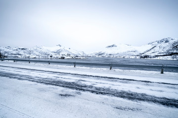 Fototapeta premium Icy road against snowcapped mountain