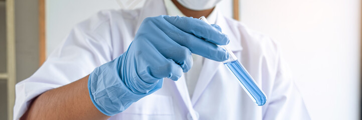 Female scientific researcher or doctor working in laboratory about virus and vaccine antiretroviral coronavirus covid19 researcher investigations with test tubes flask and blue liquid solution