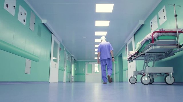 Doctor walks along an empty hospital corridor