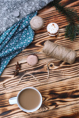 Homemade colorful macaroons are lying on the brown wooden table with cup of coffee. Cup of coffee. Anise, honey and colorful tissue.