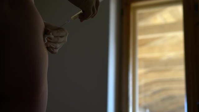 Self-injection at home. Female hands preparing for injecting buttocks.
