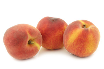 three fresh peaches on a white background