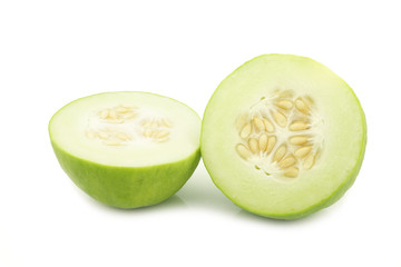 Two cumelo halves (mix between a cucumber and a melon) and a cut one on a white background