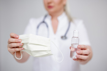 Fototapeta premium health care and corona virus pandemic concept - doctor or nurse holding sanitizer and protective mask