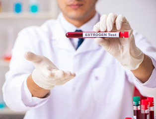 Young handsome lab assistant testing blood samples in hospital