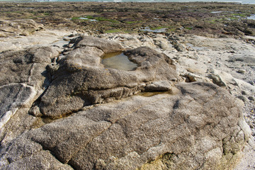Sur les rochers de la plage de Loctudy en Bretagne dans le Finistère apparaissent des bassines d'eau de mer créées par la mer lorsqu'elle est montée et qu'ensuite elle s'est retirée