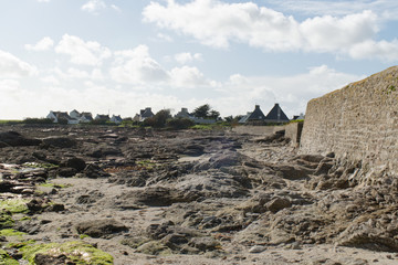 Obraz premium Une des plages de la ville de Loctudy en Bretagne dans le Finistère à marée montante laissant apparaître les rochers qui seront ensuite recouverts par la marée