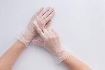 Woman apply on transparent protective gloves the cream. Medicine. Pandemic concept. Protect concept.