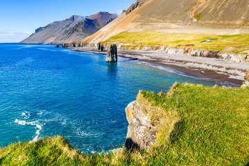 Iceland. Picturesque landscape of fantastic Icelandic nature during summer time season. View of ocean, sophisticated cliffs with green grass, amazing mountains in background. Golden Circle of Iceland.