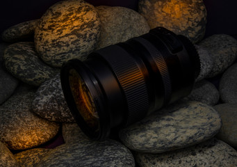 SLR camera lens closeup on stones in background