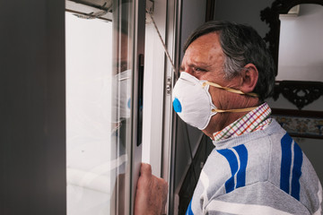 Man with mask looking out the window