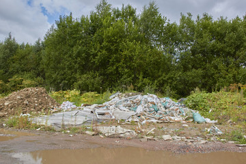 illegally dumped garbage on the background of green nature