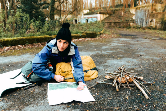 Hiker navigating with map and compass in countryside