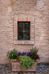 Fototapeta na wymiar detail of a flower pot located near a window of an ancient house