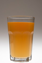 Ein Glas mit orangem Multvitaminsaft