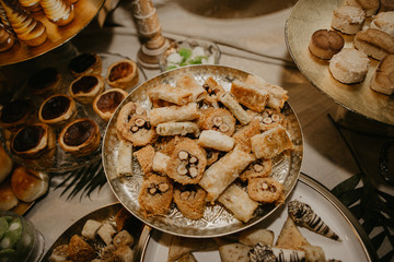 From above ornamental plates with delicious fresh desserts placed on banquet table during wedding celebration