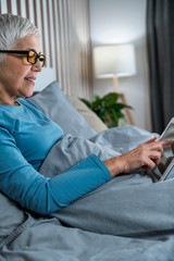 Mature Woman Wearing Blue Light Blocking Eye Glasses, Using Tablet
