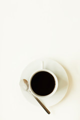 Above view at minimal composition of black coffee cup over white background in cafe, copy space