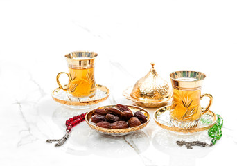 Golden tea cups dates rosary beads decoration Ramadan kareem