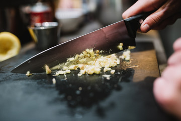 Closeup anonymous person chopping fresh ingredient with sharp knife during cooking course in restaurant kitchen in Navarre, Spain