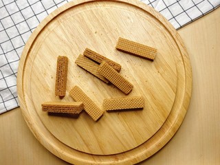 Baked crispy chocolate and coffee Wafers on wooden plate.