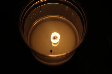 A burning candle in glass