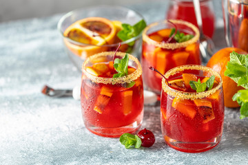 Three glasses of Italian aperol spritz cocktail with orange slices and ingredients on light gray...