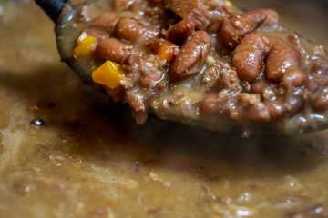 close up macro view of red beans and rice stew that was cooked for a tasty delicious dinner. the vegetables are vibrant with steam coming from the soup. a healthy organic meal was prepared.