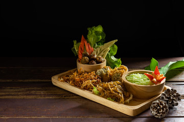 Rice cooked with pandan leaves in water (Khao Chae) and fried shrimp paste, sweet pork, fried peppers stuffed with pork stuffing, sweet Radish on the wooden plate.